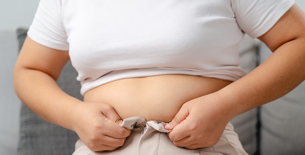 Person struggling with weight loss mistakes and tight pants