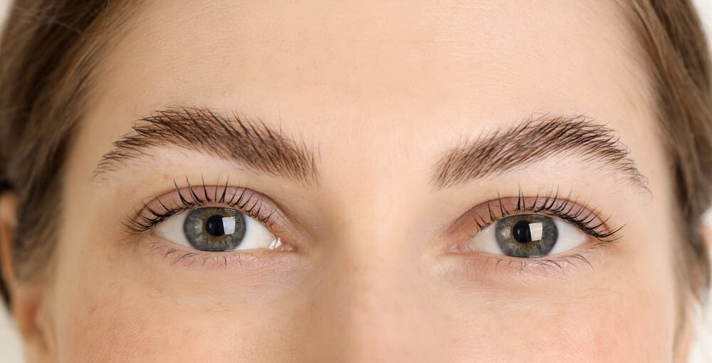 Close-up of woman applying what is Latisse eyelash growth treatment along upper lash line