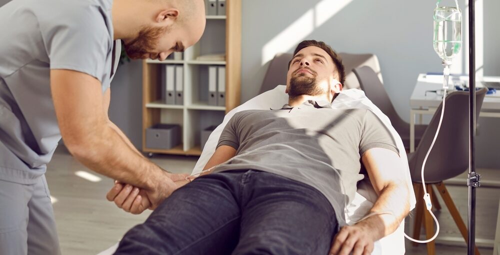 ale patient receiving IV hydration appointment at a wellness clinic while provider inserts IV line